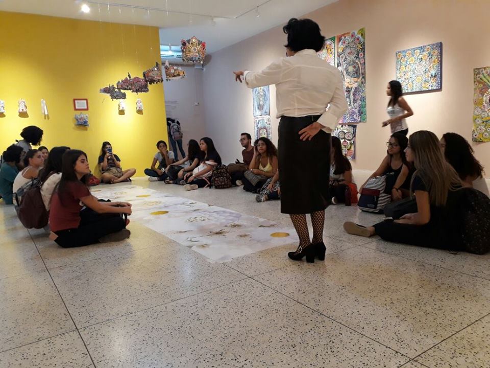 Coordenadora da Gaeu, Neusa Mendes, recebe estudantes na galeria, sentados em roda